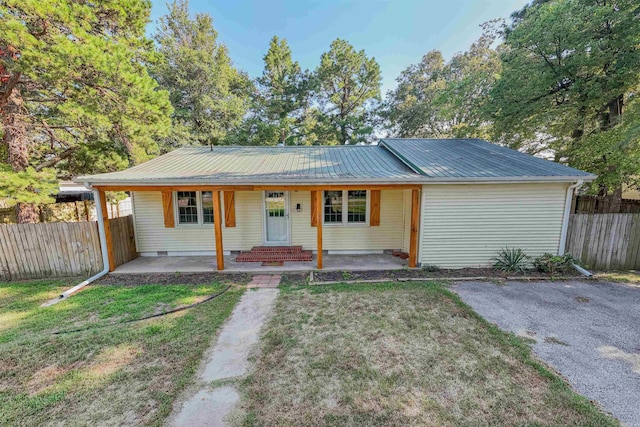 ranch-style house featuring covered porch and a front yard