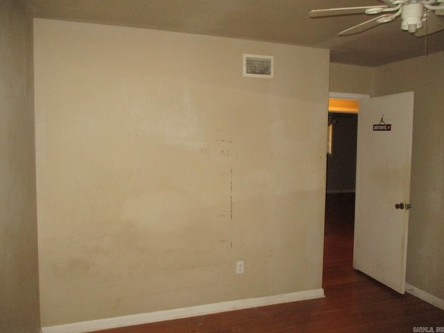 spare room featuring ceiling fan and dark wood-type flooring