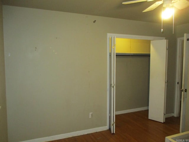 unfurnished bedroom featuring ceiling fan, dark hardwood / wood-style floors, and a closet