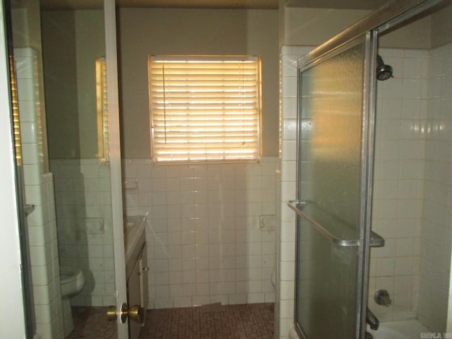 bathroom featuring vanity, toilet, and tile walls