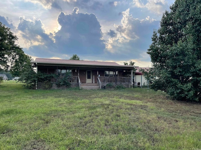 back house at dusk with a yard and a porch