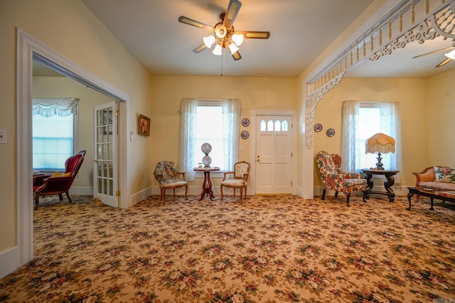 carpeted foyer entrance with ceiling fan and a healthy amount of sunlight