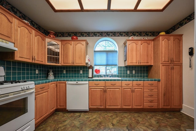 kitchen featuring sink, white appliances, decorative backsplash, and tile counters