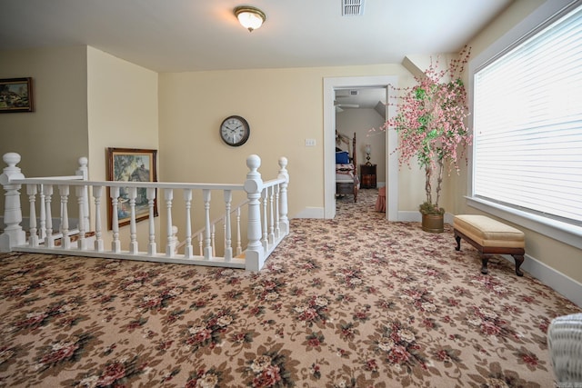 corridor with plenty of natural light and light carpet