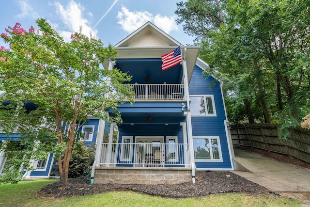 rear view of property with a balcony and a porch