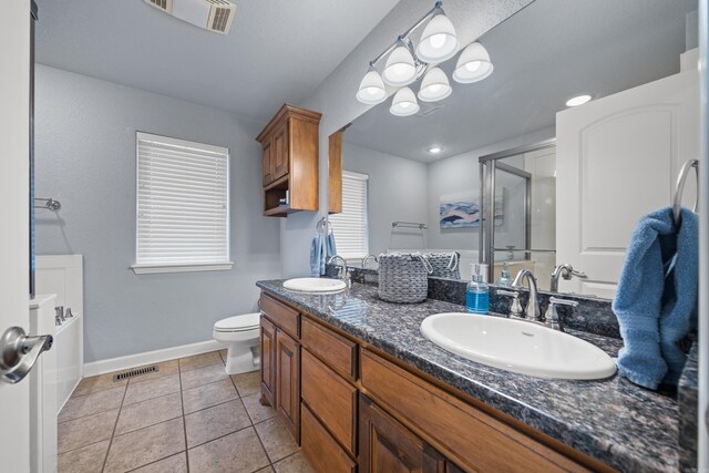 bathroom featuring tile patterned floors, double sink vanity, and toilet