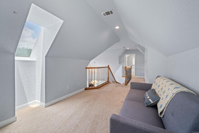 interior space with vaulted ceiling with skylight and light carpet