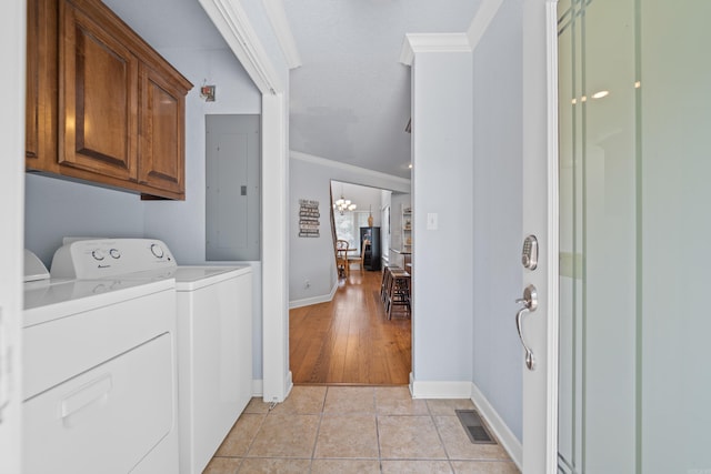 clothes washing area featuring an inviting chandelier, light hardwood / wood-style floors, electric panel, crown molding, and independent washer and dryer