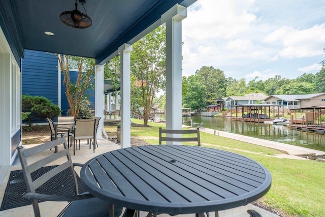 view of patio / terrace with ceiling fan, a boat dock, and a water view