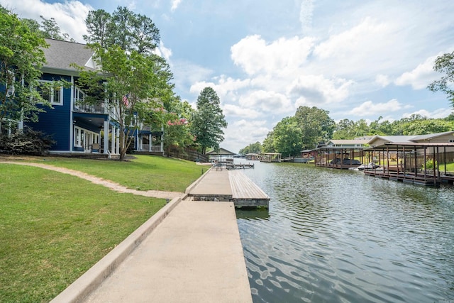 view of dock with a yard and a water view