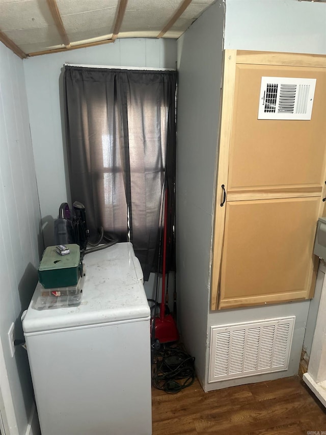 clothes washing area featuring washer / clothes dryer and dark hardwood / wood-style floors