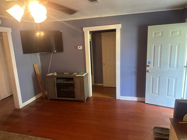 living room featuring ceiling fan, dark wood-type flooring, and a textured ceiling