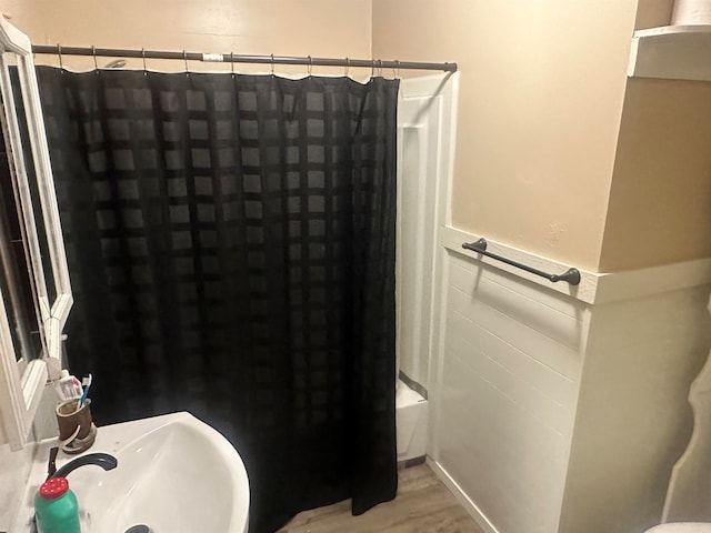 bathroom with sink, shower / bathtub combination with curtain, and wood-type flooring