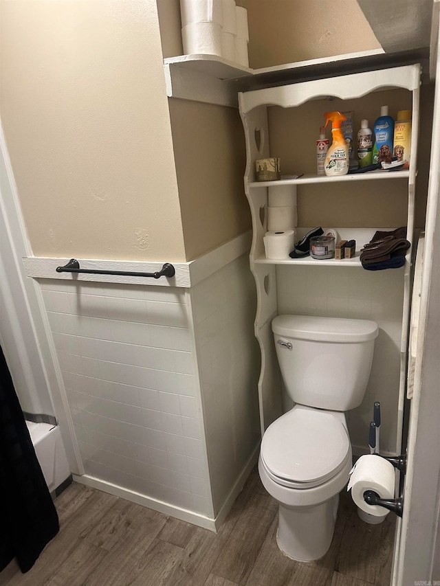 bathroom with shower / bath combination, hardwood / wood-style floors, and toilet