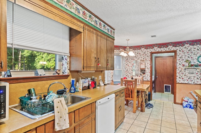 kitchen with a chandelier, sink, a textured ceiling, light tile patterned floors, and white dishwasher