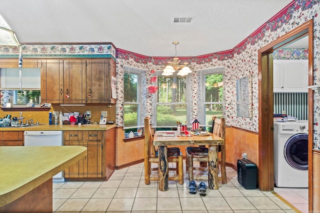 kitchen featuring dishwasher, a chandelier, a textured ceiling, washer / dryer, and light tile patterned floors