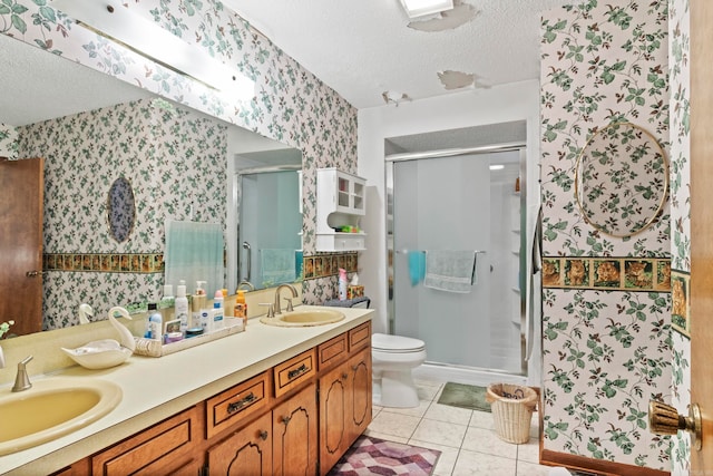 bathroom featuring tile patterned floors, a shower with shower door, double vanity, a textured ceiling, and toilet