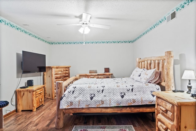 bedroom featuring hardwood / wood-style floors, ceiling fan, and a textured ceiling