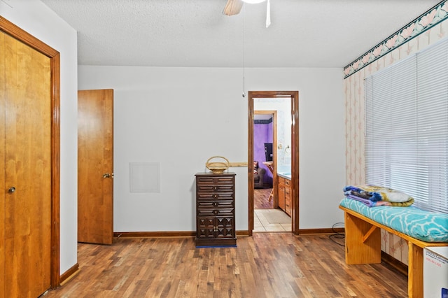 interior space with ceiling fan, a textured ceiling, and hardwood / wood-style floors