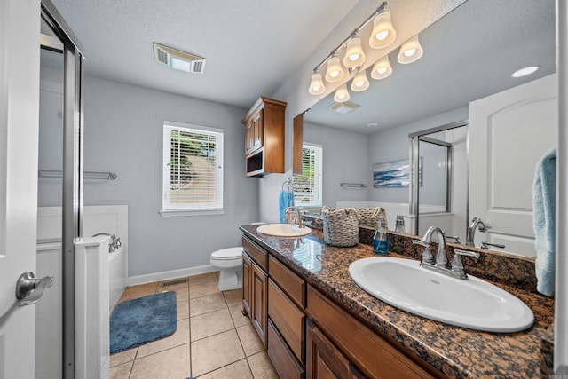 bathroom with toilet, tile patterned flooring, a textured ceiling, vanity, and walk in shower