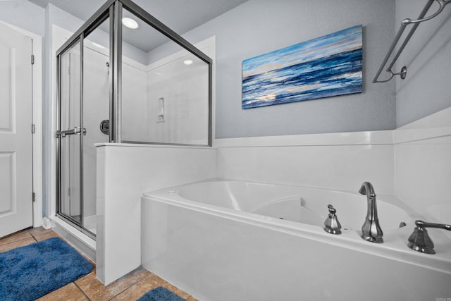 bathroom with tile patterned flooring, separate shower and tub, and a textured ceiling