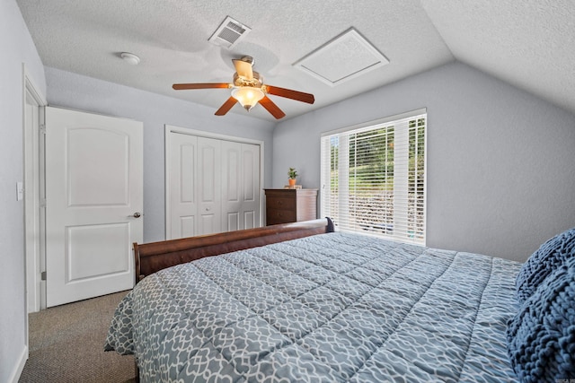 carpeted bedroom with a textured ceiling, ceiling fan, vaulted ceiling, and a closet