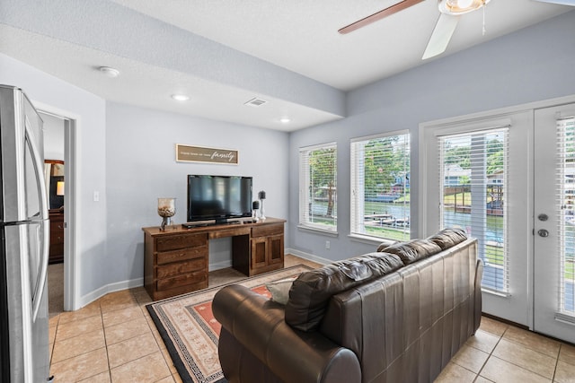 tiled living room featuring ceiling fan and a textured ceiling