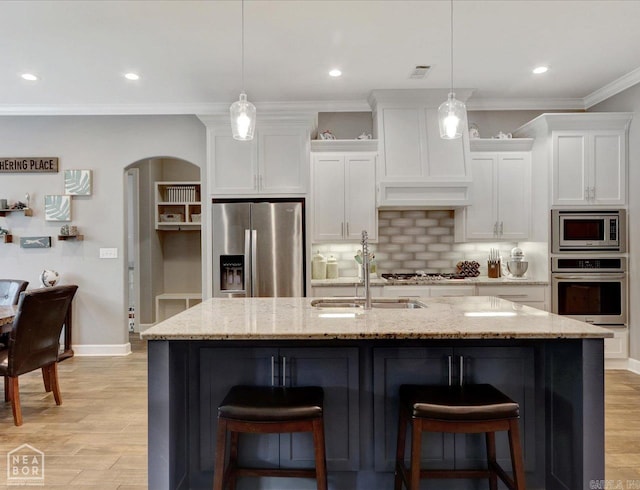 kitchen featuring stainless steel appliances, tasteful backsplash, sink, crown molding, and light wood-type flooring