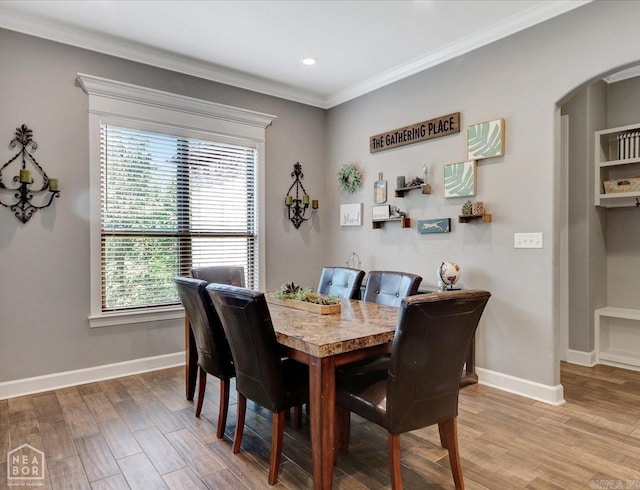 dining space with wood-type flooring and ornamental molding