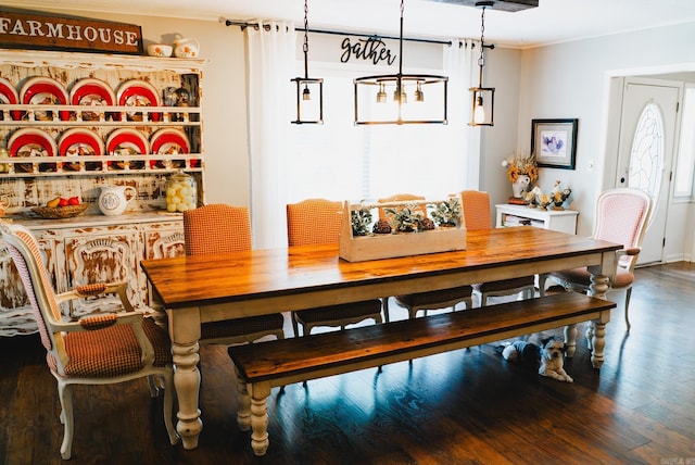 dining area with crown molding and wood finished floors