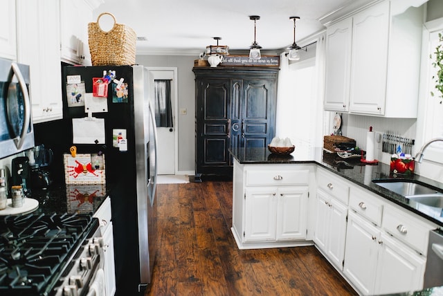 kitchen featuring dark hardwood / wood-style flooring, dark stone countertops, white cabinetry, and ornamental molding