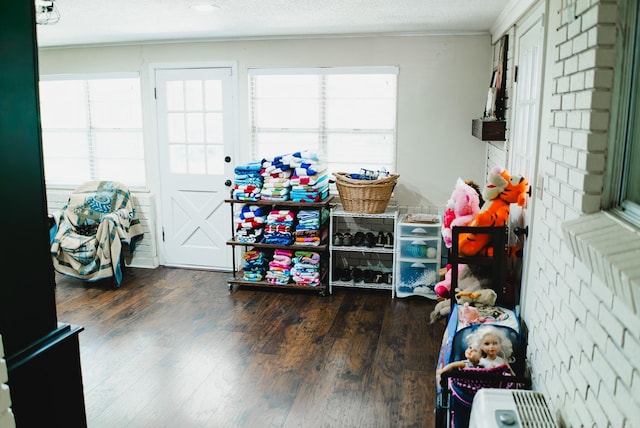 playroom with hardwood / wood-style flooring, ornamental molding, and a textured ceiling