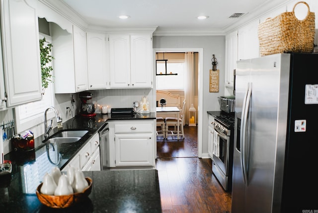 kitchen with appliances with stainless steel finishes, dark wood-type flooring, a healthy amount of sunlight, and white cabinetry