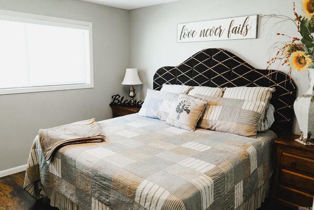 bedroom with baseboards and wood finished floors