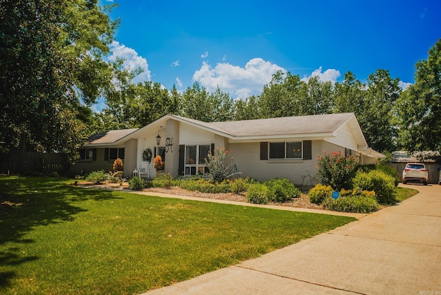 single story home featuring brick siding and a front yard