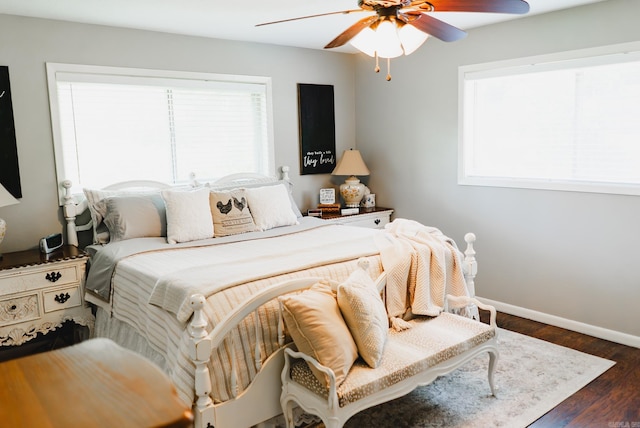 bedroom with multiple windows, dark hardwood / wood-style floors, and ceiling fan