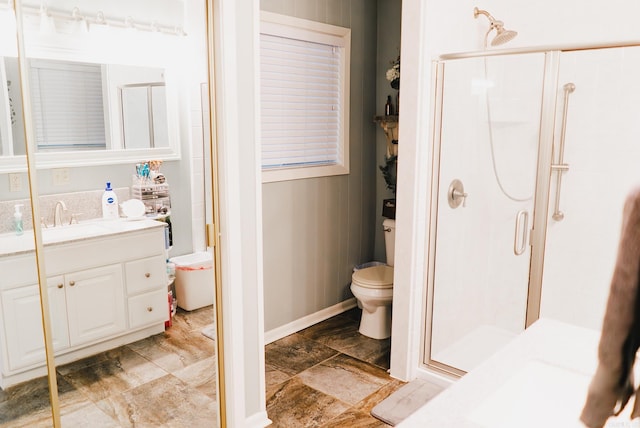 bathroom featuring tile patterned flooring, toilet, vanity, and a shower with shower door