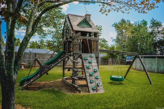 view of playground with a lawn and fence