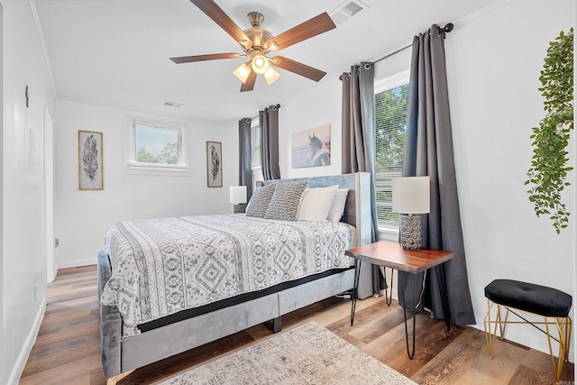 bedroom featuring ceiling fan, crown molding, and wood-type flooring