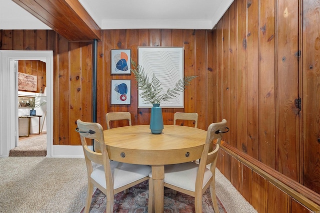 dining space featuring wood walls and carpet