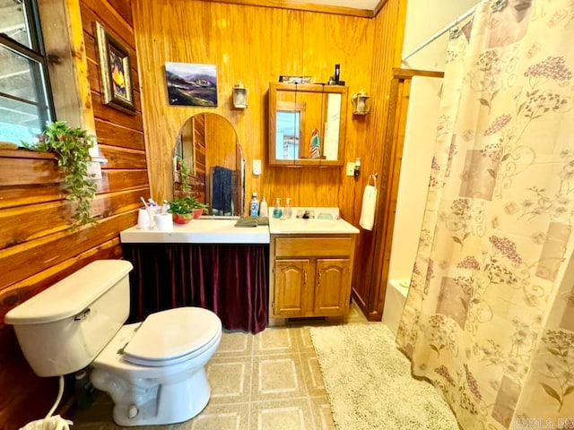 bathroom with wooden walls, tile patterned floors, toilet, and vanity