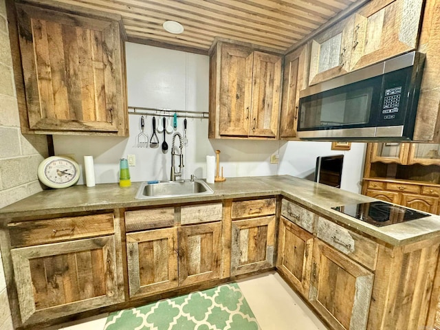 1499 Sutterfield Rd, Fox, AR 72051 - kitchen with stainless steel microwave, a sink, black electric cooktop, brown cabinetry, and a peninsula