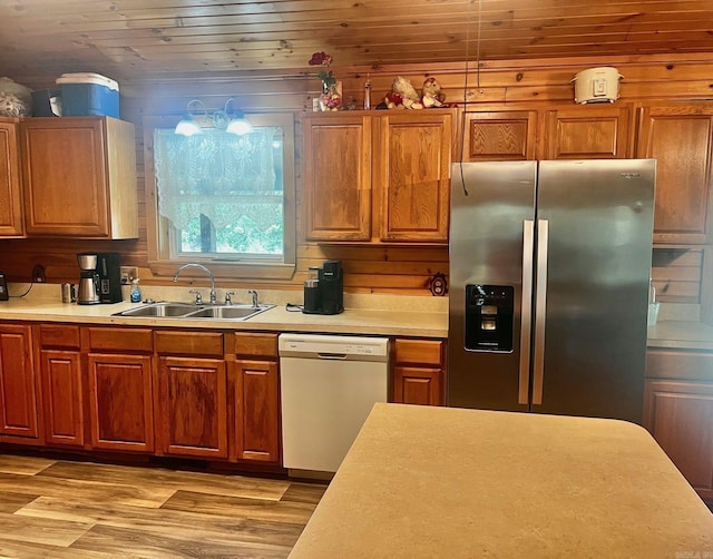 kitchen featuring white dishwasher, a sink, light wood-style floors, light countertops, and stainless steel refrigerator with ice dispenser