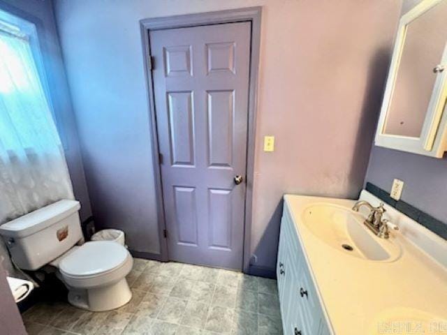 bathroom featuring tile patterned flooring, vanity, and toilet