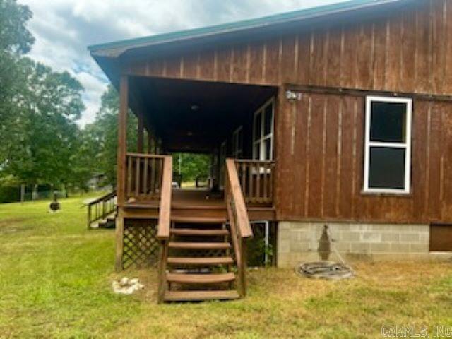 view of property exterior with a deck and a lawn