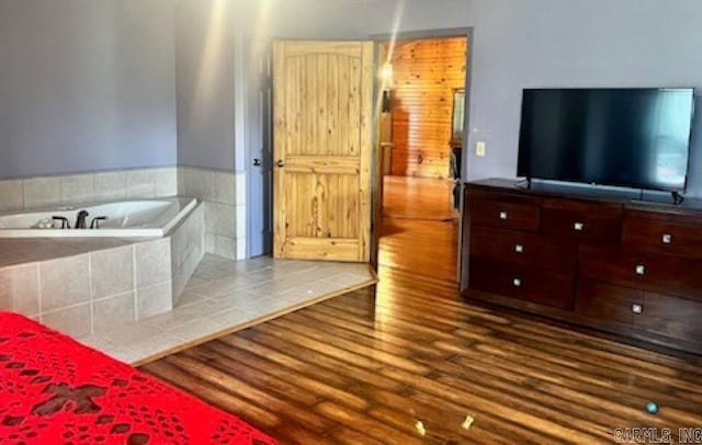 bathroom with a garden tub and wood finished floors