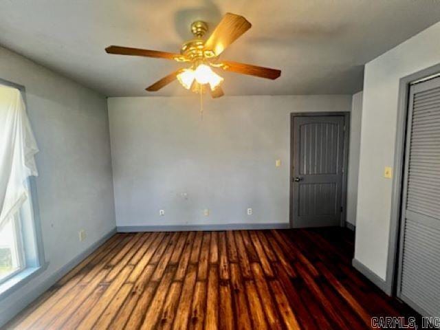 spare room featuring baseboards and wood finished floors