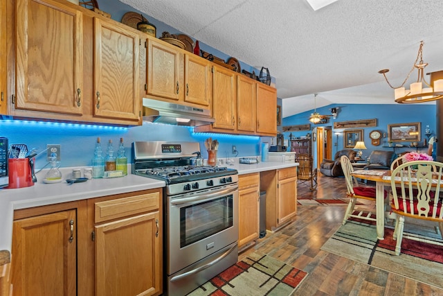 kitchen featuring dark hardwood / wood-style flooring, stainless steel range with gas stovetop, vaulted ceiling, a textured ceiling, and pendant lighting