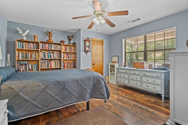 bedroom featuring ceiling fan, dark hardwood / wood-style floors, and a textured ceiling