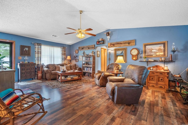 living room featuring ceiling fan, vaulted ceiling, a textured ceiling, and wood-type flooring